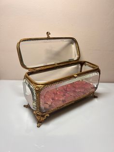 a glass case with red rocks in it on a white counter top next to a mirror