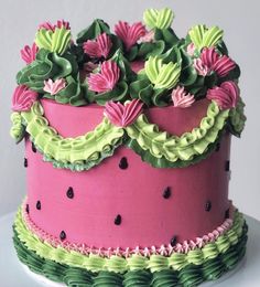 a pink and green cake with flowers on top