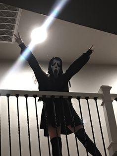 a woman with her arms up in the air while standing on a stair case next to a railing