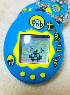 an electronic device keychain is shown on a white surface with chinese characters in the background