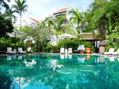 an outdoor swimming pool with chairs and umbrellas