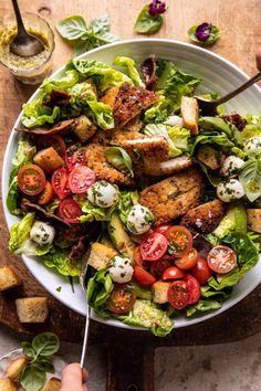 a salad with chicken, tomatoes and lettuce