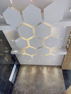 an overhead view of a room with hexagonal ceiling tiles and lights on the walls