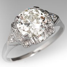 an antique style diamond ring with baguetts on the shoulders and sides, set in white gold