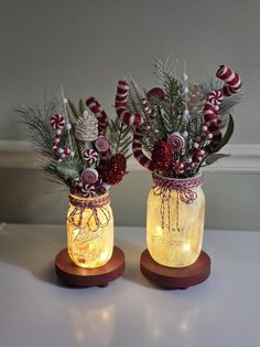 two mason jars filled with candy canes and greenery