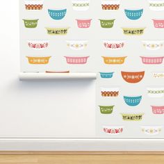 wallpaper with colorful bowls on it in a kitchen area next to a white shelf