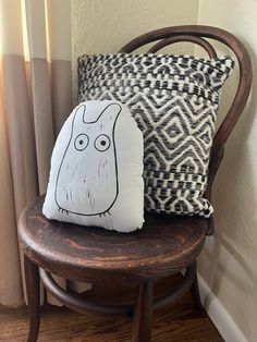 two pillows sitting on top of a wooden chair