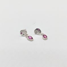 These gorgeous dangling earrings feature and handmade starry silver disk with one pink sapphire set on each side and a beautiful garnet that sparkles on the bottom. Each earring is handmade and therefore unique and will differ from one an other. ✨ Silver care - the studs of these earrings are made with sterling silver and may cause an allergic reaction in people sensitive to metal. Silver is easy to care for, avoid contact with water, and polish with light jewelry cloth or mild jewelry cleanser Pink Sapphire Round Earrings As Gift, Pink Sapphire Earrings As A Gift, Sterling Silver Pink Birthstone Earrings, Pink Sterling Silver Birthstone Earrings, Pink Birthstone Earrings In Sterling Silver, Pink Birthstone Drop Earrings, Pink Garnet, Light Jewelry, Allergic Reaction