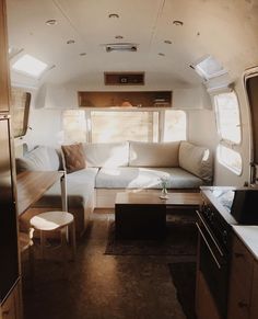 the interior of an rv with couches and tables