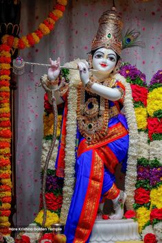 a statue of the hindu god ganesh in front of flowers and garlands on display