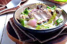 a bowl filled with meat and vegetables on top of a table