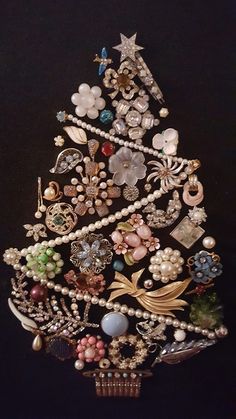 a christmas tree made out of pearls, brooches and other items on a black background