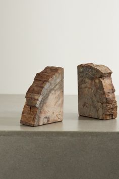 two pieces of wood sitting on top of a cement countertop next to each other