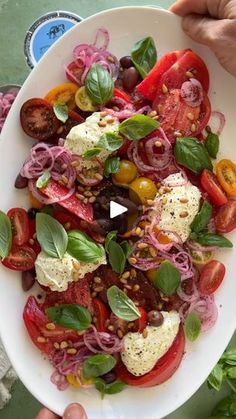 a white plate topped with lots of different types of food on top of a table