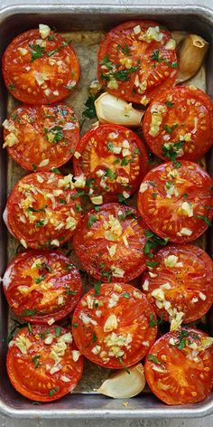 tomatoes with garlic and seasoning in a baking pan