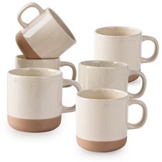 four coffee mugs stacked on top of each other in different shapes and sizes, one with a brown rim