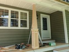 a wooden clock on the front porch of a house