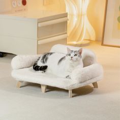 a cat laying on top of a white chair in a child's nursery room