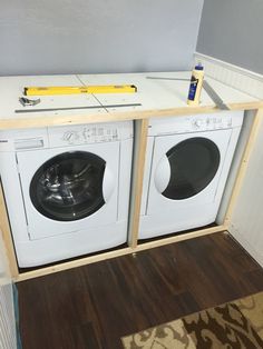 two washers are sitting in front of the dryer