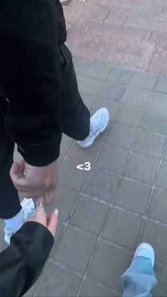 two people standing next to each other holding hands