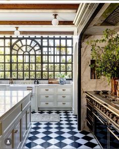 a kitchen with black and white checkered flooring next to a stove top oven