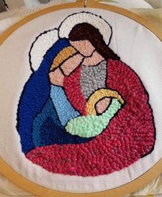 a cross stitched onto a piece of cloth with an image of the virgin mary