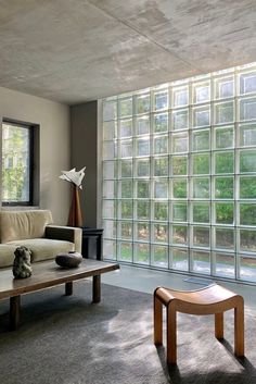 a living room filled with furniture and large glass blocks on the wall above it's windows