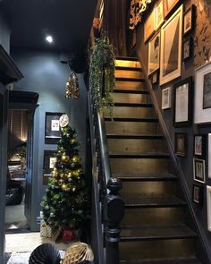 the stairs are decorated with christmas lights and garlands, along with pictures on the wall