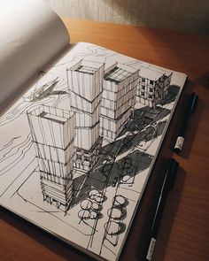 an open notebook with a drawing of buildings on the cover and a pen next to it