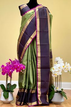 This beautiful saree in pistachio green shot black is handwoven. The rettai pettu border in betelnut shot with black color and purple selvedge is flanked in chakram and geometric motifs in gold zari. The body is adorned with chakram motifs while the grand pallu is decorated with paisleys along with traditional motifs in gold zari. Blouse piece is in betelnut shot with black color. Approximate Length 6.5 mtrs (inclusive of blouse length) Height - 46 - 52" Approximate weight - 1.6 lbs Saree comes Green Shot, Kanjivaram Silk Saree, 40th Gifts, Traditional Motifs, Silk Cotton Sarees, Geometric Motifs, Pistachio Green, Cotton Sarees, Blouse Length