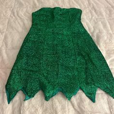 a green dress laying on top of a bed