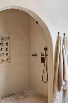 a bathroom with an arched shower head and hand held shower faucet in it