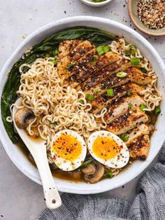 a bowl filled with noodles, chicken and hard boiled eggs