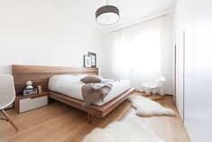 a bedroom with white walls and wood flooring