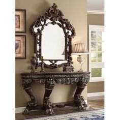 an ornately decorated console table with mirror and lamps on the wall in a living room