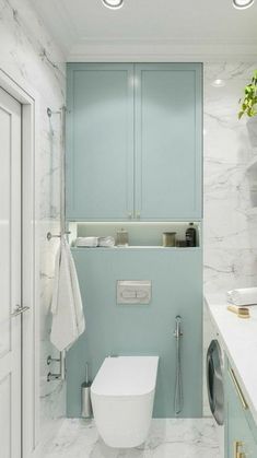 a white toilet sitting next to a washer and dryer in a bathroom under two lights