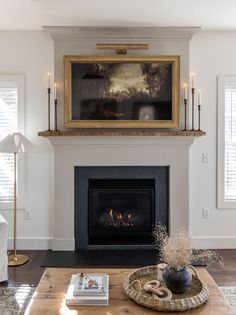 a living room filled with furniture and a fire place in front of a painting on the wall