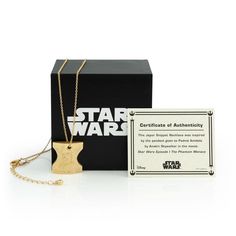 a star wars necklace with a card in front of it and a box on the side