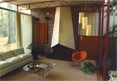 a living room filled with furniture and a fire place next to a large glass window