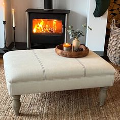 a living room with a fire place in the corner and candles on the table next to it