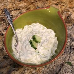 a bowl filled with cucumber and yogurt on top of a counter