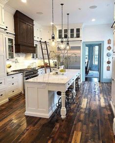 a large kitchen with wooden floors and white cabinets