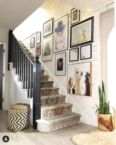 a staircase with pictures on the wall next to it