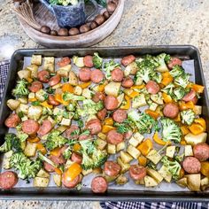 a pan filled with sausage, broccoli and potatoes