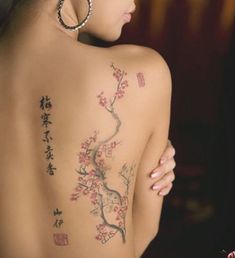 the back of a woman's body with tattoos on it