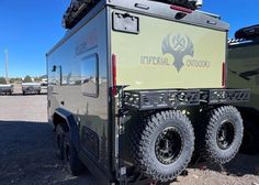 an off - road vehicle parked in a parking lot next to another vehicle with the words imperial school on it