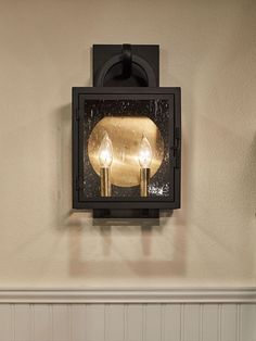 a wall mounted light with two lights on it's side and a mirror in the middle