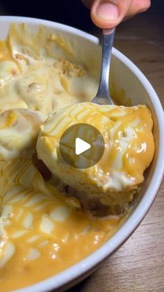 a person is spooning some food out of a bowl with cheese and sauce on it