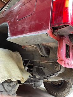 the rear end of a red truck parked in a garage