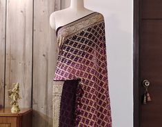 A lovely Shaded Wine Banarasi Khaddi Georgette Bandhani Saree in gorgeous pattern. Its a fusion of karigari of Banarasi and Gujarati. Additional Information Color : Purple Wine shaded Technique: Bandhani is a tye & dye technique in which fabric is pinched with nails and tied with thread and then dyed to create fabulous patterns. Fabric: Pure Georgette Blouse Piece: Included Since this product is handwoven, there might be slight irregularities. But doesn't that add to the singular charm of a handloom beauty? Bollywood Style Brocade Pre-draped Saree With Zari Work, Festive Pre-draped Brocade Saree With Zari Work, Purple Bandhani Print Traditional Wear For Wedding, Purple Bandhani Traditional Wear For Wedding, Fitted Brocade Saree With Dupatta, Festive Purple Bandhani Print Lehenga, Diwali Brocade Pre-draped Saree With Dupatta, Diwali Fitted Embroidered Fabric With Zari Weaving, Purple Wedding Sets With Bandhani Print